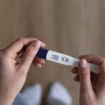 detail-na-zenske-ruky-zena-drzi-tehotensky-test