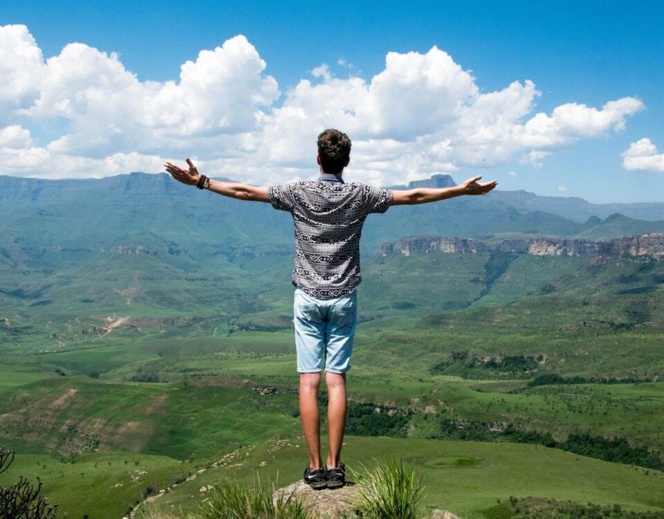 muz-s-roztiahnutymi-rukami-na-kopci-nad-krajinou